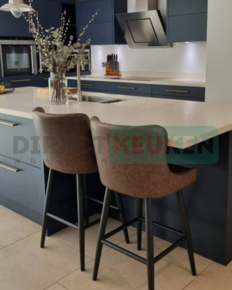 Donkerblauwe keuken met goudkleurige grepen en een eiland met zitplaatsen